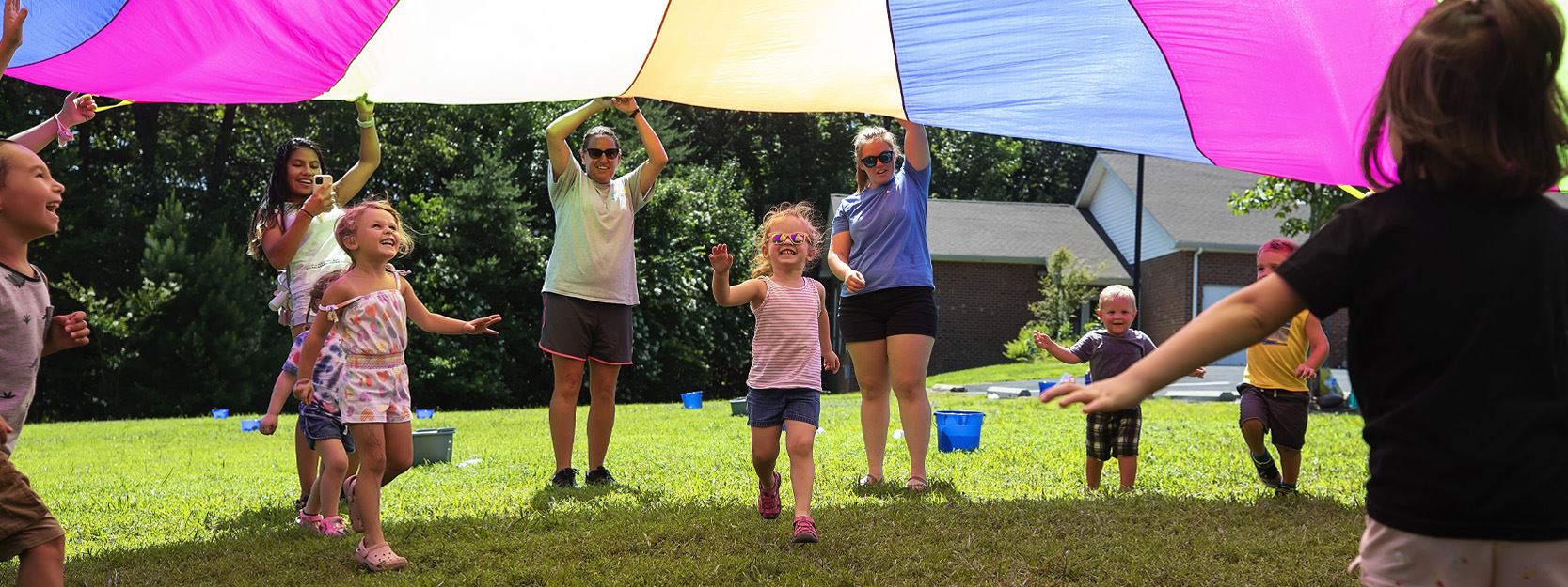 Children running under a parachute