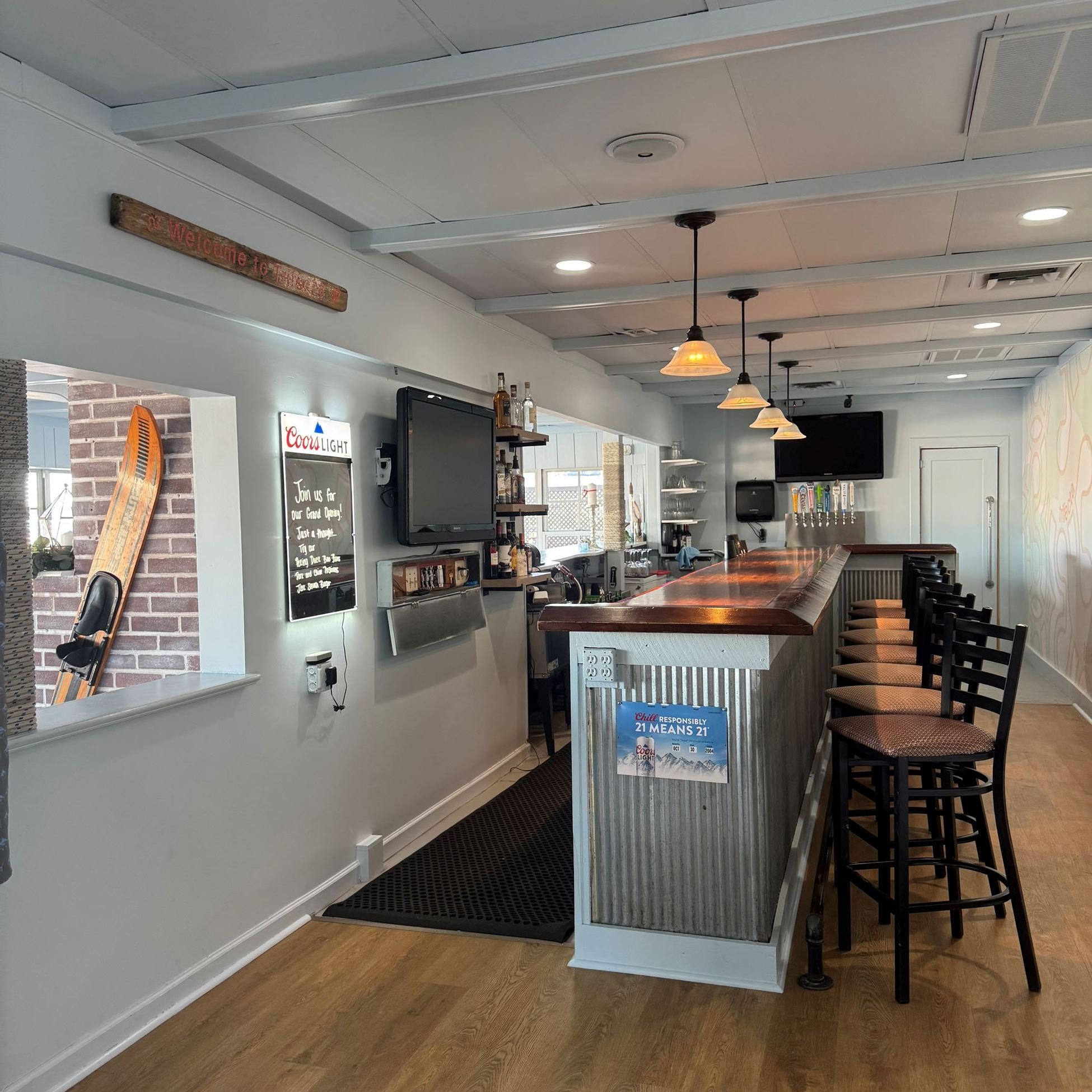 bar counter and chairs in a room with wooden flooring